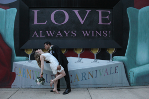 Bride and groom in front of love sign