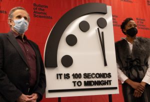 Robert Rosner and Suzet McKinney stand in front of the Doomsday Clock, which reads "It is 100 seconds to midnight."