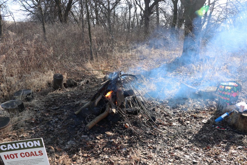 A fire burns under the watchful eye of two Field Museum conservation ecologists. (Penelope Gardner/MEDILL)