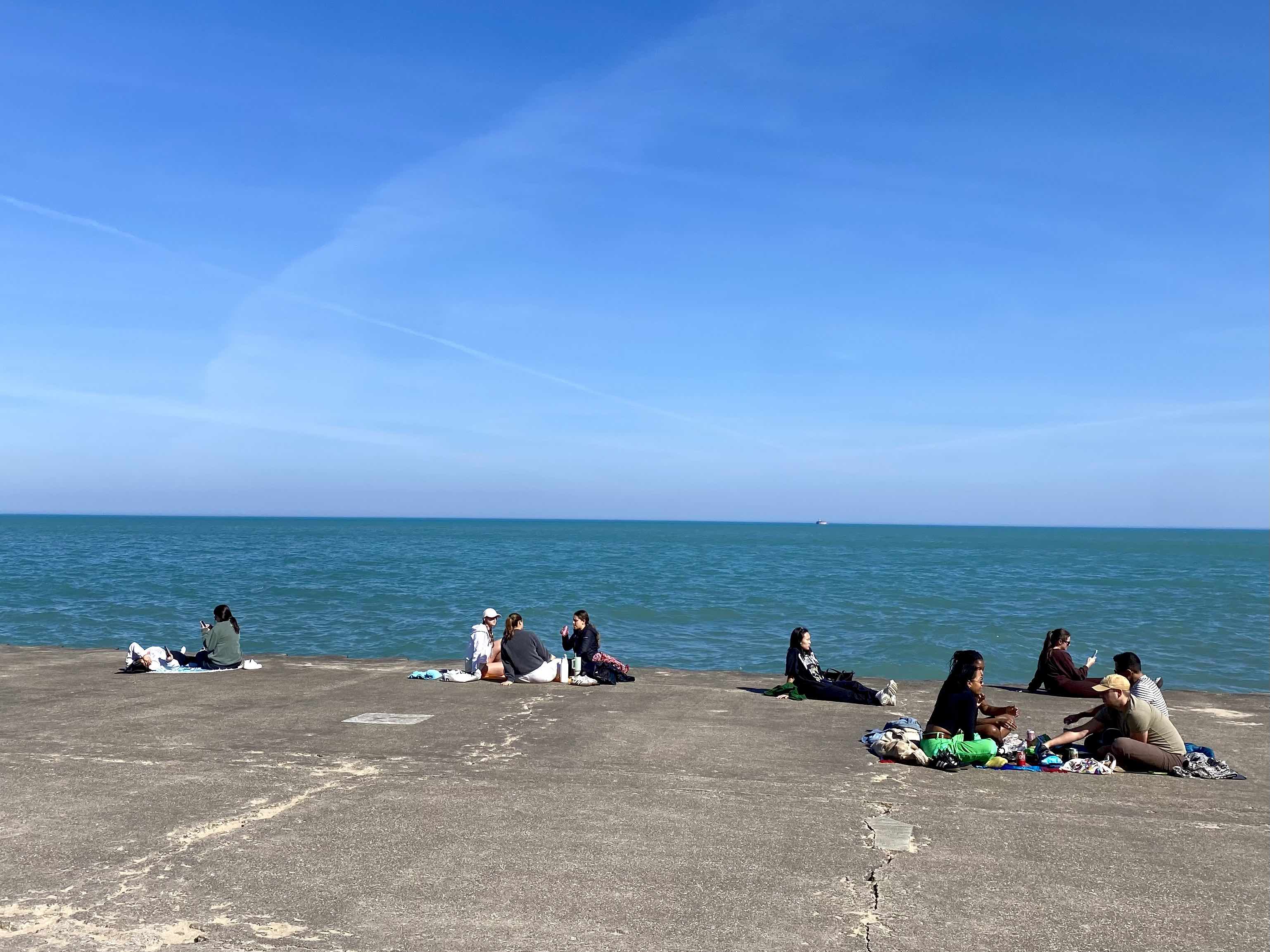 People sitting by the lakefront.