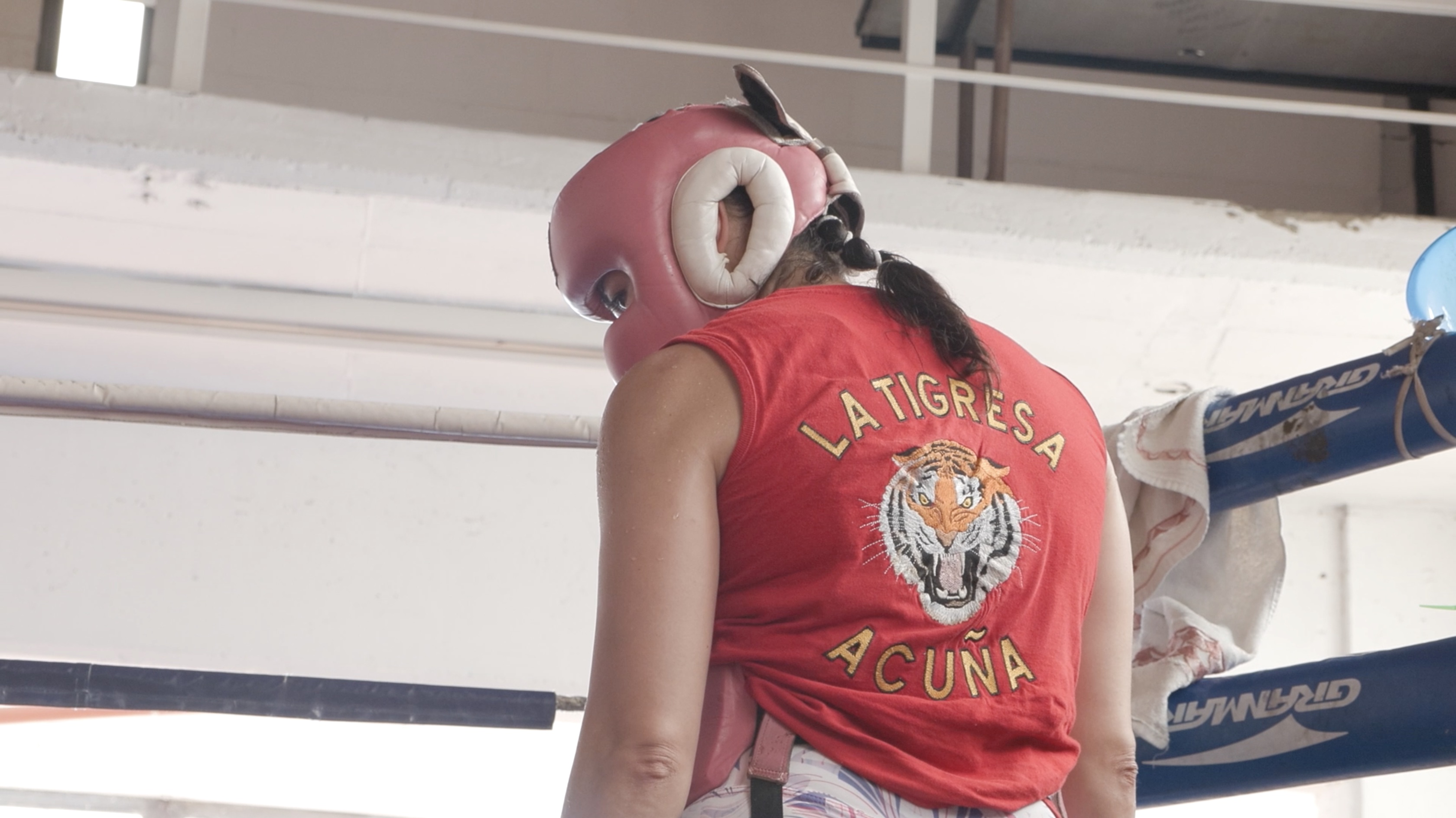 The female The Argentinian boxer Marcela Acuna stands on the ring. She wears a red t-shirt where you can read "La Tigresa Acuna".