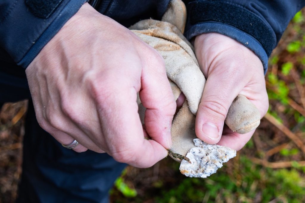 Sam Kelley poses for a photograph April 14 in Ireland’s Wicklow Mountains. The gray-colored quartz at the surface of the rock contains a radioactive isotope called beryllium-10 that forms from cosmic rays. (Cathy Ching / Medill)