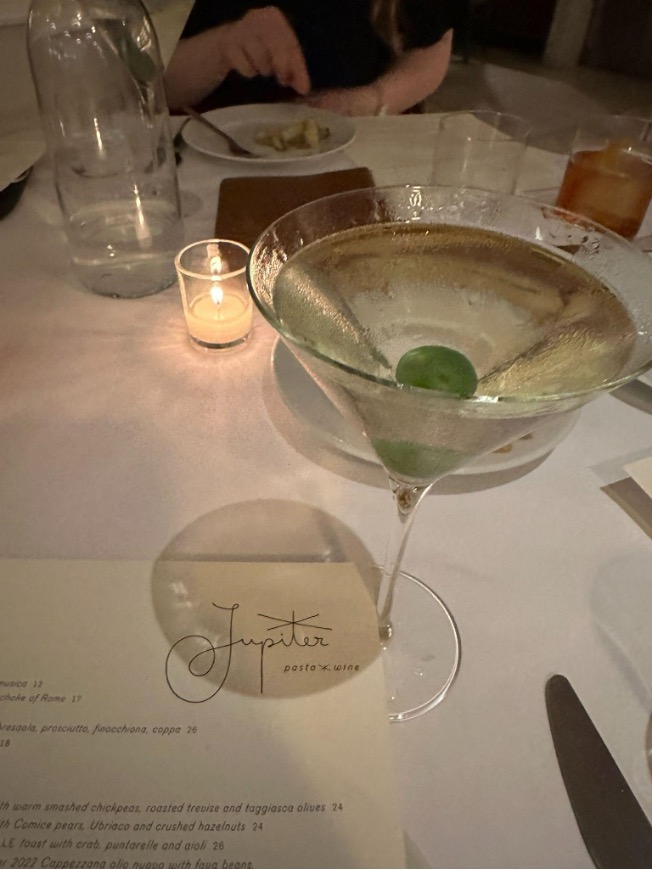 Martini and menu on table between two people on a date.