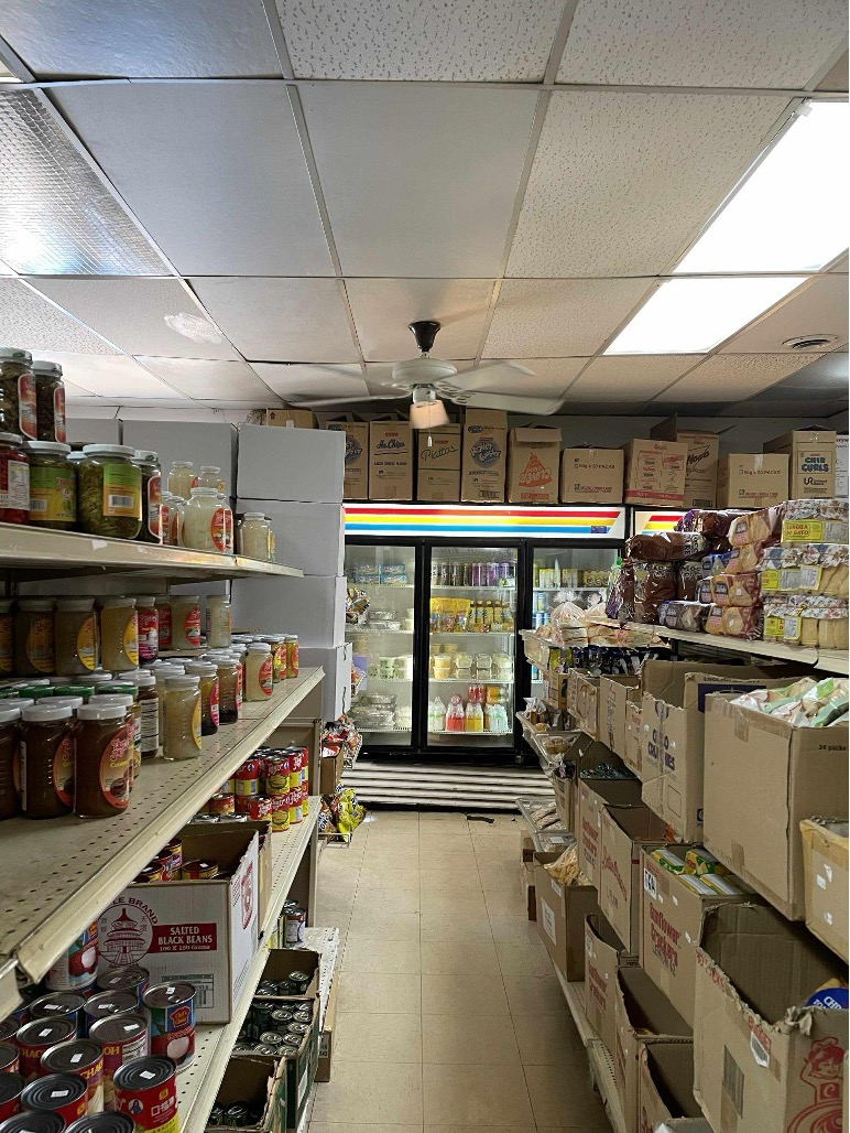 Filipino grocery store aisle with shelves and refrigerators with Filipino food products.