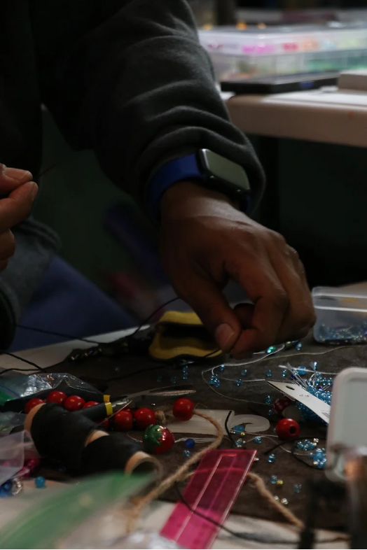 Closeup of artist's hands working with beads