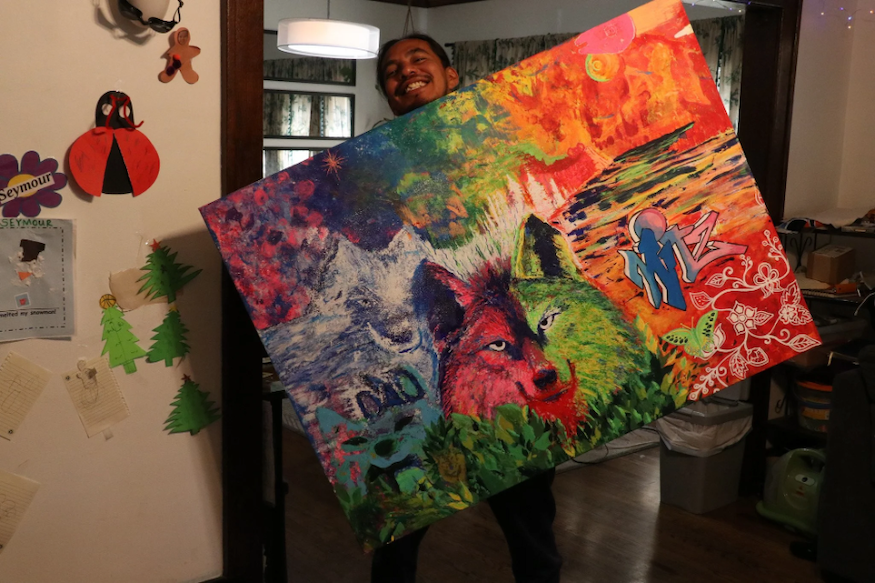 Artist holding vibrant painting