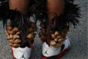 Dried seeds of the chachayotl tree and other adornments tied around ankles above Air Jordan shoes