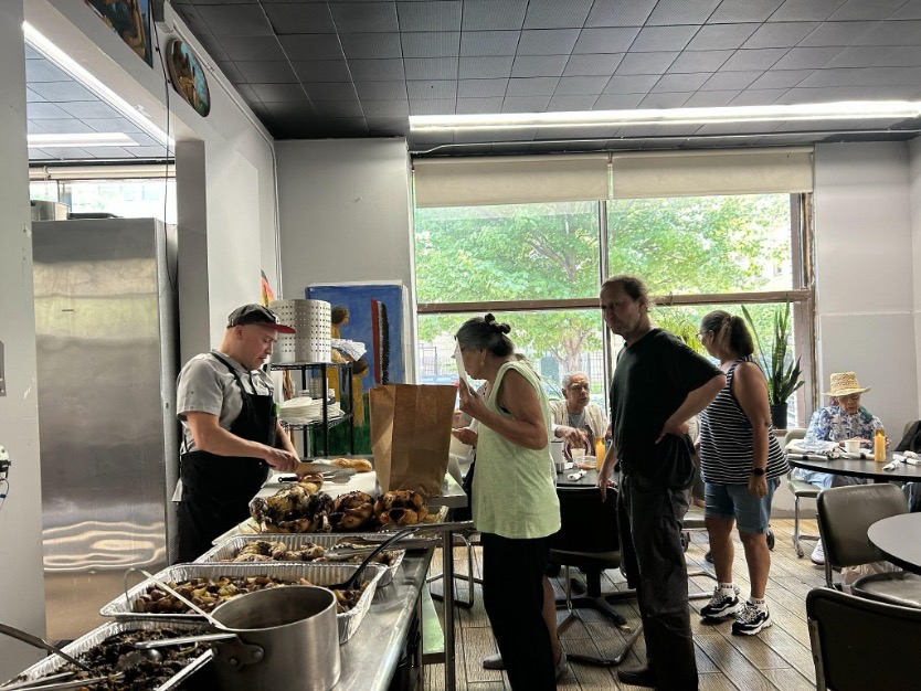 Elders line up to get food prepared by chef
