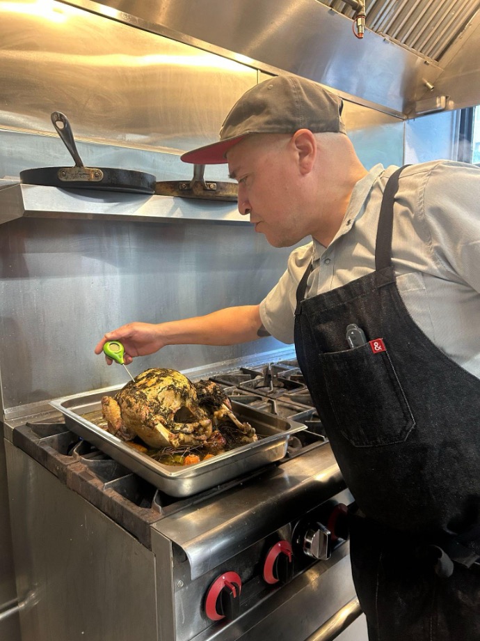 Chef checks dish's temperature with thermometer