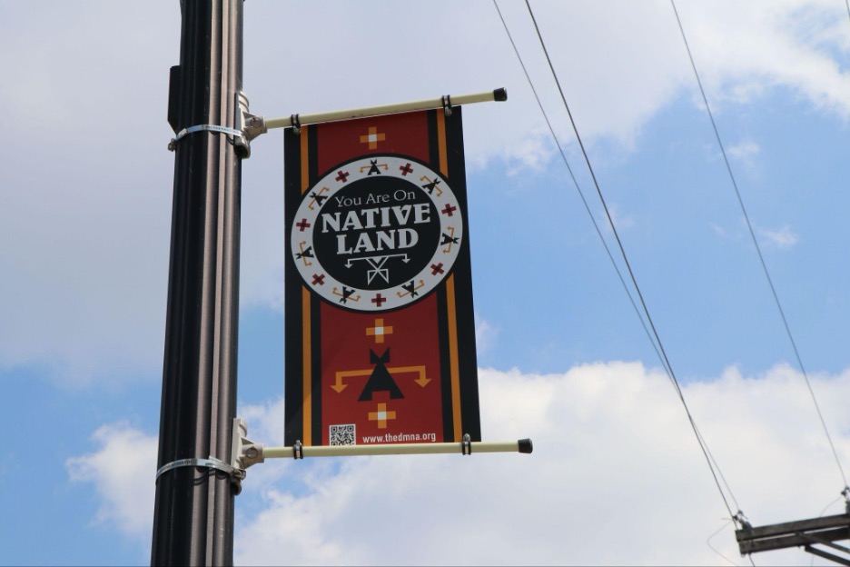 Banner hanging from post reads "You are on Native land"