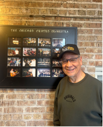 Orlando Rivera beams as he looks at pictures of the Chicago Cuatro Orchestra around his office at Humboldt Park Fieldhouse on Jan. 8, 2026, including his 2007 “dream team” of musicians.