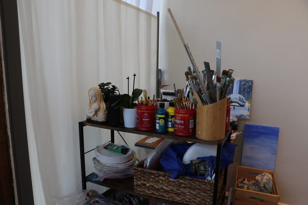 Artist's paintbrushes and art supplies on shelf