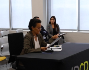 Woman reads document at table.