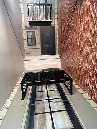 Black metal bench on trompe l'oeil floor