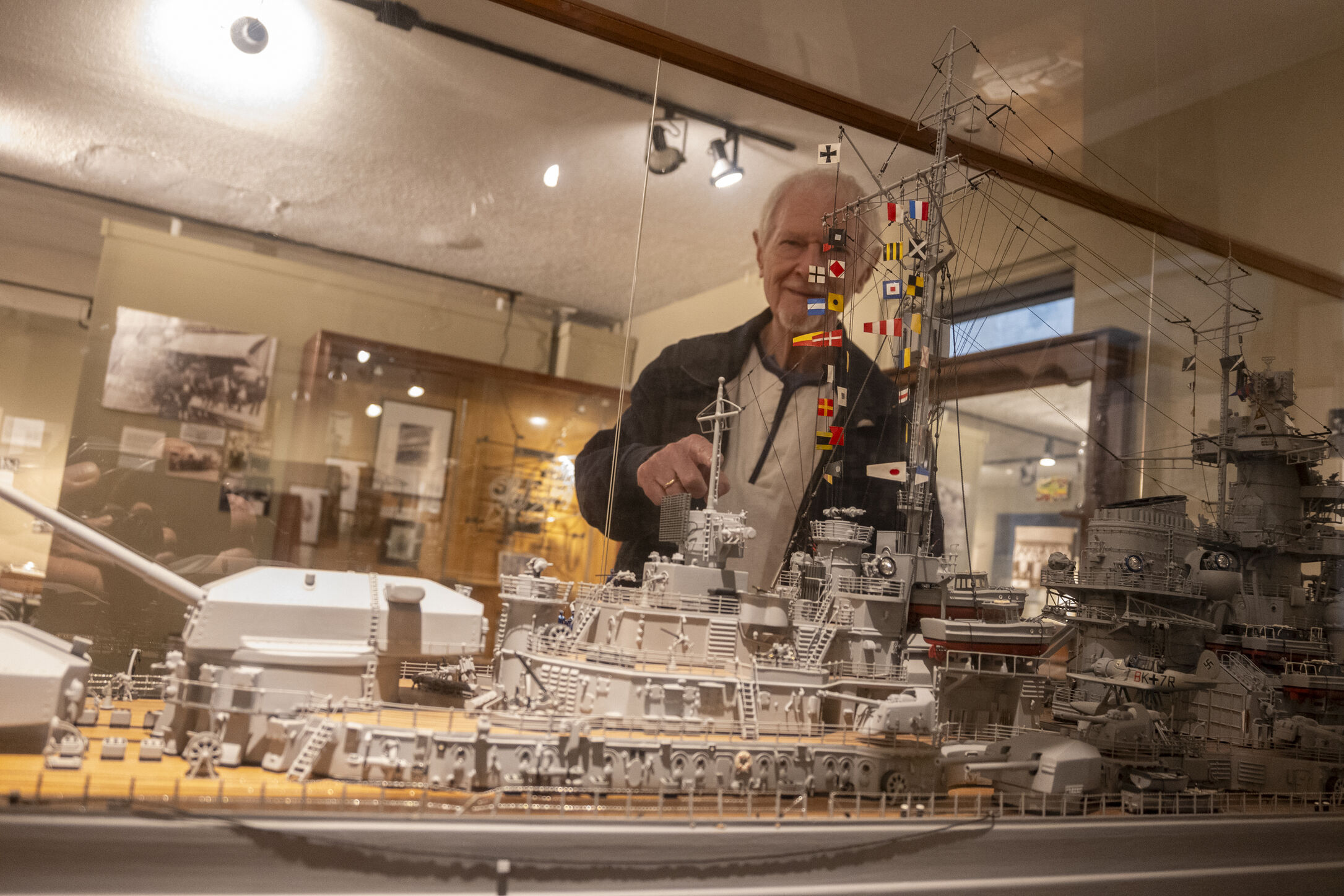 Man points at detailed ship model in museum
