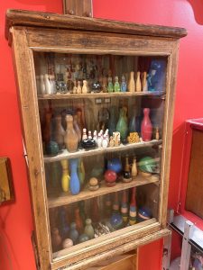 Wooden display cabinet with bowling pins and balls.