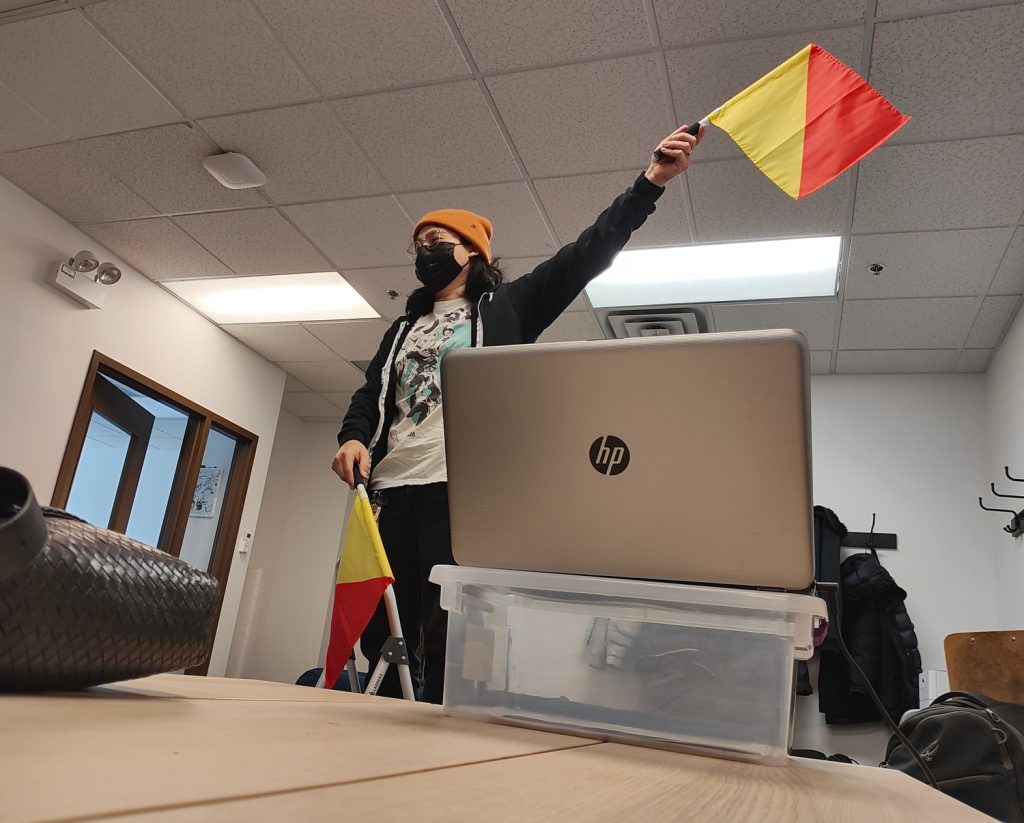 Ari Garcia-Chow participates in an unconventional flag-based communication game at an event at the Chicago Game Lab on Feb. 21. (Conner Dejecacion/MEDILL)