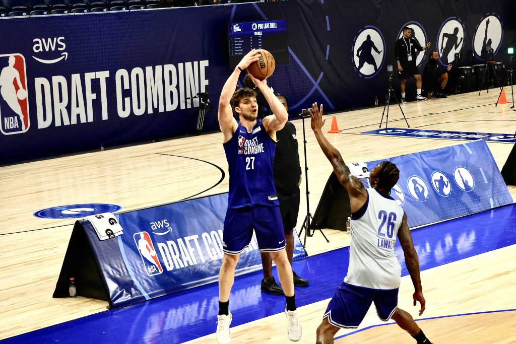 Ο βορειοδυτικός φόργουορντ Νικ Μαρτινέλι εκτοξεύει ένα αμφιλεγόμενο τρίποντο εναντίον του επιθετικού της Βιρτζίνια Τεκ, Τόμπι Λόουαλ, κατά τη διάρκεια του αγώνα. (Κέβιν Λου/ΜΕΝΤΙΛ) 