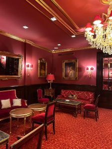 Elegant red-themed room with chandelier and artwork