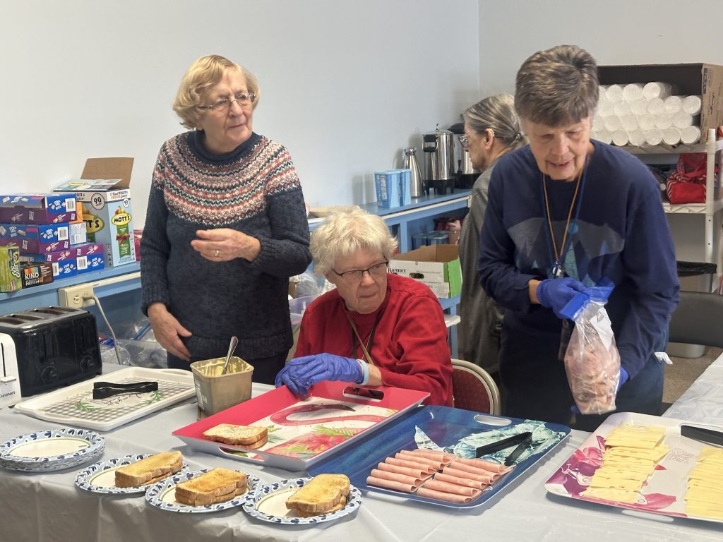 Women preparing sandwiches at a table
