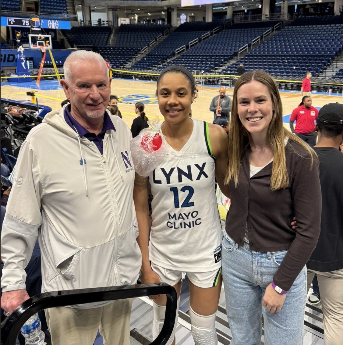 Former Northwestern women’s basketball coach Joe McKeown, left, and current assistant coach Maggie Lyon, right, caught up with Minnesota Lynx player and Northwestern alum Nia Coffey after the Chicago Sky game May 23. Days later, Lyon returned to watch her former teammate score a season high 20 points in a 79-58 win May 29. (Photo courtesy of Joe McKeown)