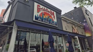 Restaurant storefront with closed patio umbrellas.