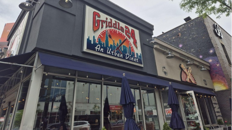 Restaurant storefront with closed patio umbrellas.