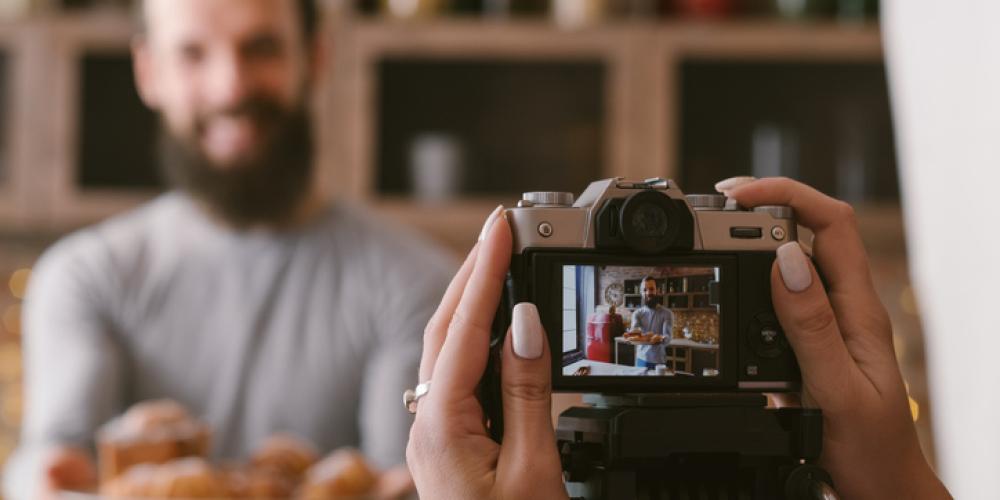 Person taking picture of man, view from camera LCD screen