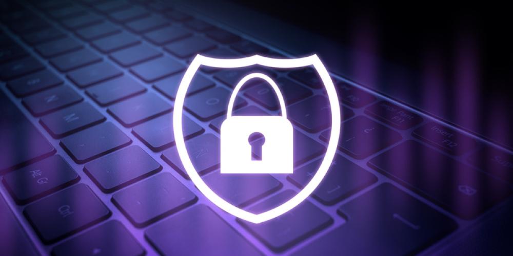 badge with lock overlayed over laptop, symbolizing cybersecurity