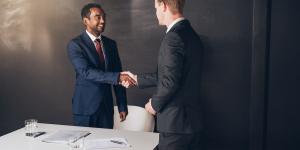 two men shaking hands in an office