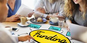 Finance: It's All About the Money People gathered around funding Grant Donation Diagram Concept at a table