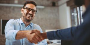 Male business owner shakes someone's hand Male business owner shakes someone's hand