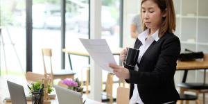 asian woman standing looking at a document