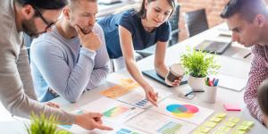 Create the business plan that's right for you Team gathered around a table looking at different color palettes