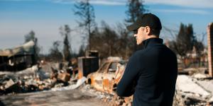 Man owner checking burned and ruined business