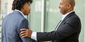 Mature African American casually dressed businessman shaking hands.