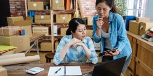 2 Young asian women looking at a tablet with customer orders