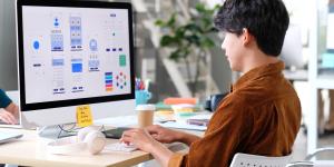 Young asian man UX designer working on smartphone application at office