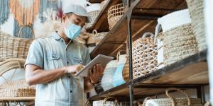 male business owner keep working and wear face masks at his art and craft store