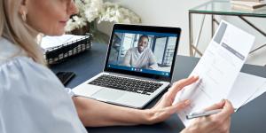 Female hr reading cv during online virtual job interview by video call.