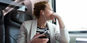 Woman listening to podcast on train