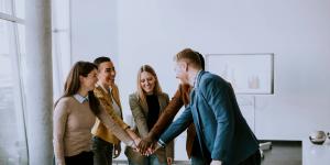 Team of young entrepreneurs with their hands together in a huddle