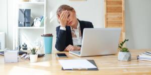 Woman facepalming while working.