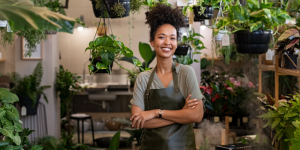 Young black woman in her plant shop smiling Young black woman in her plant shop smiling