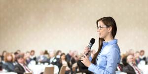 Business woman speaking to large audience. Business woman speaking to large audience.