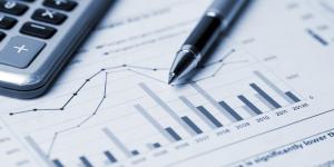 Photo of a business chart with a calculator and pen atop.