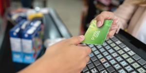 person gives loyalty card to cashier