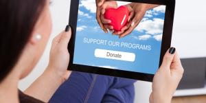 20 Essential Apps to Help Your Nonprofit Succeed woman donating to charity on tablet