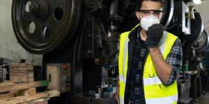 KKR Small Business Builders Grant man wearing a hard at and vest in auto shop