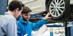 11 Ways to Find Your First Customers man in blue button up talking to customer and showing them car tires